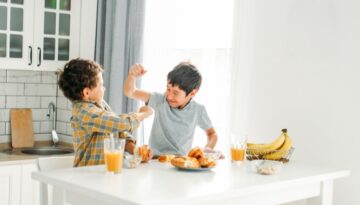 Two boys hitting each other while eating breakfast. Bosshard Parke Insurance Policy Coverage.