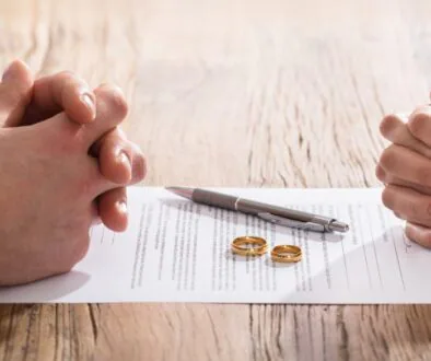 Couple sitting around divorce papers with their wedding rings in the center. Bosshard Parke Wisconsin Divorce.