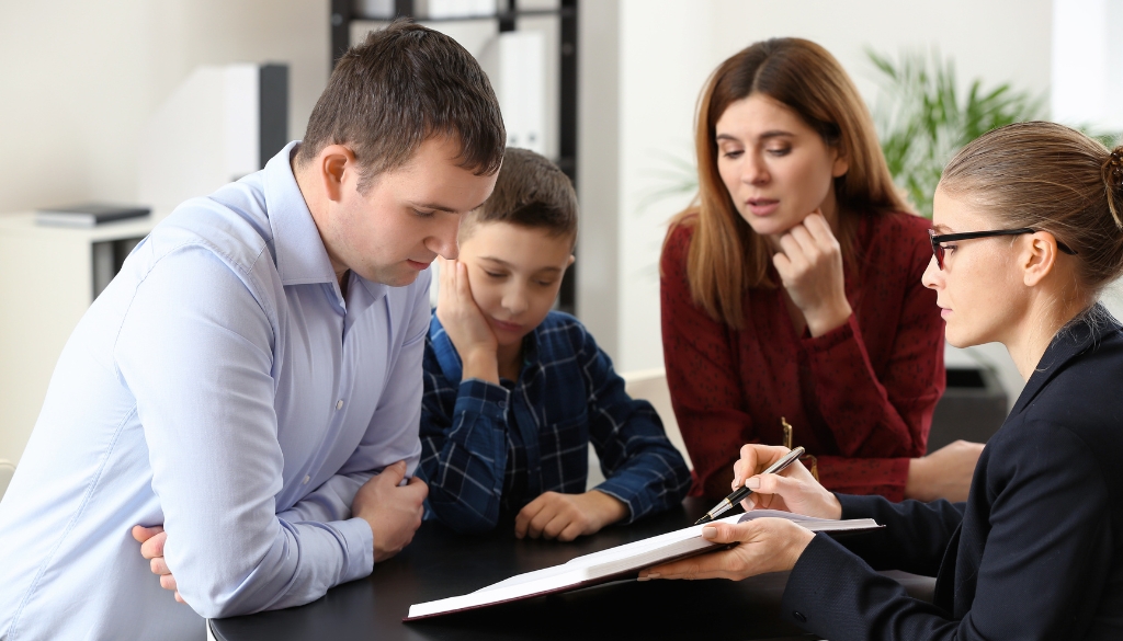Parents and their child discuss legal matters with an attorney. Navigating child custody in MN & WI. Bosshard Parke.