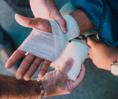 Paramedic bandaging an injured person's hand. Bosshard Parke Personal Injury Attorney.