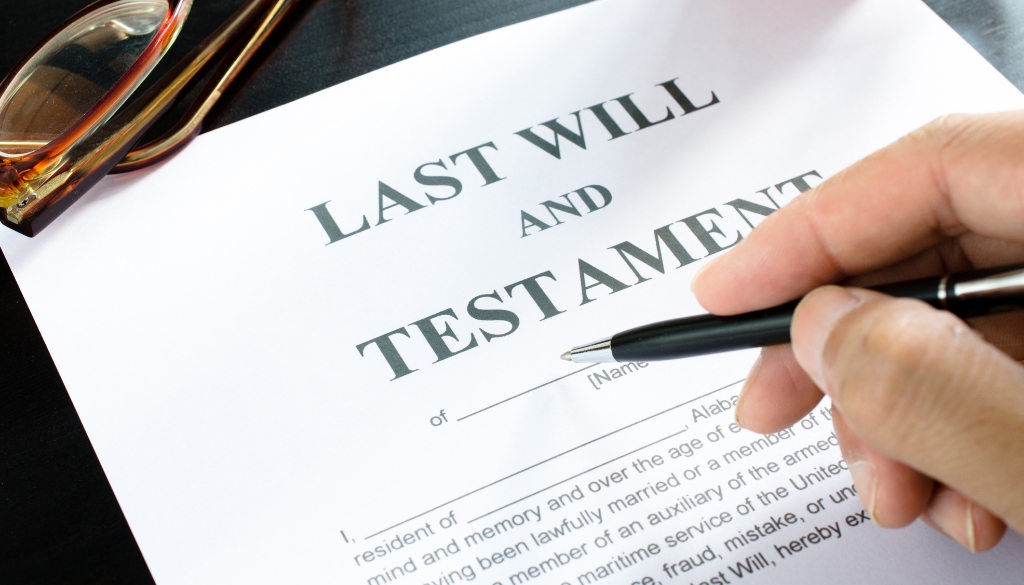 Person fills out a Last Will and Testament legal document.