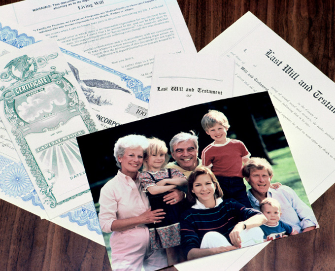 Photograph of a family including grandparents, parents, and children sits on top of a Last Will and Testament Legal Document. Probate and Administration Law at Bosshard Parke, in La Crosse, WI.