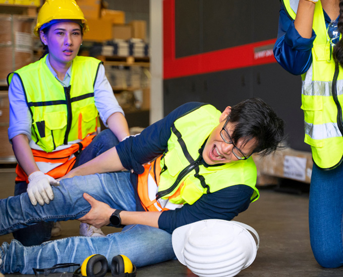 Worker screams in pain laying on the floor after being injured on the job. Workers' Compensation and Personal Injury Law at Bosshard Parke, La Crosse, WI.