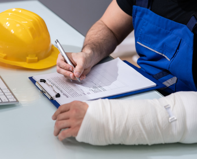 Worker with broken arm fills out paperwork. Personal Injury Law in La Crosse, WI at Bosshard Parke.