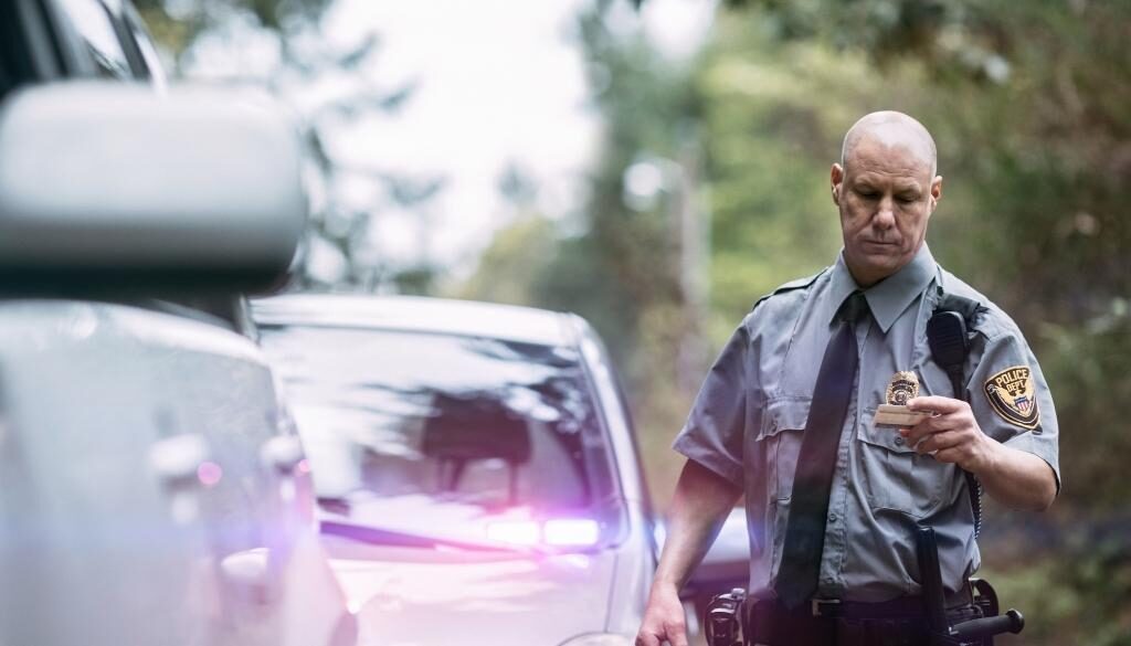 Police officer looks at an ID during a traffic stop.