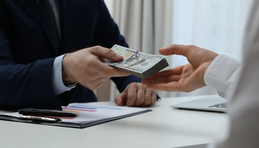 Man handing his ex-wife a cash payment.