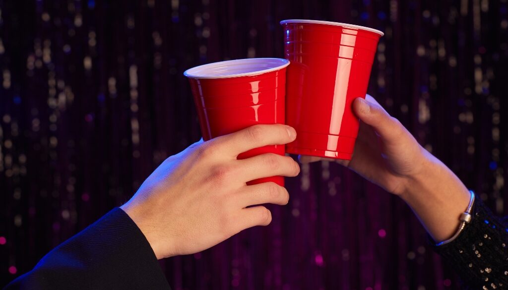 Two hands holding red solo cups