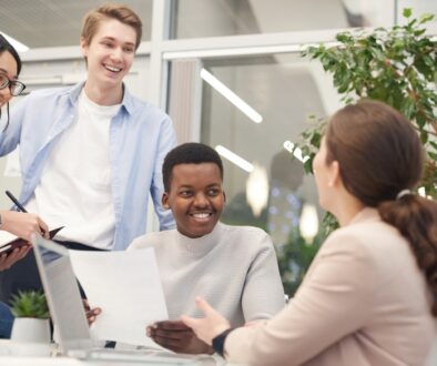 A business professional meeting with three interns.