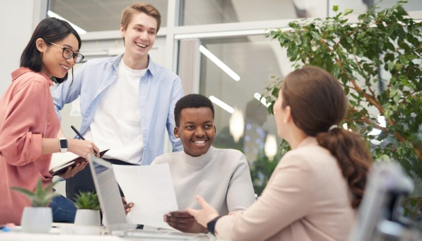 A business professional meeting with three interns.