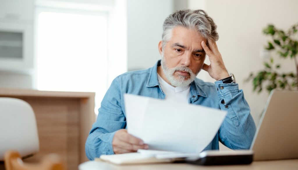 Concerned man reviewing medical bills at home, trying to understand how medical payment insurance (Med Pay) coverage works in Wisconsin personal injury cases.