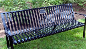 A black city park bench that has been donated in memory of Ben Smith.