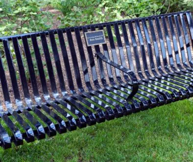 A black city park bench that has been donated in memory of Ben Smith.