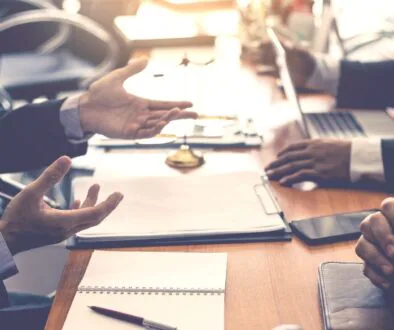 Professionals having a meeting in a law office, with documents, a laptop, and a gavel on the table.