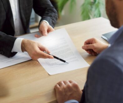 An attorney reviews and explains a settlement offer document to a client during a professional consultation in an office setting.
