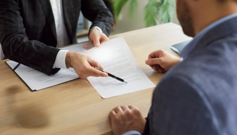 When To Accept or Reject a Settlement Offer An attorney reviews and explains a settlement offer document to a client during a professional consultation in an office setting.