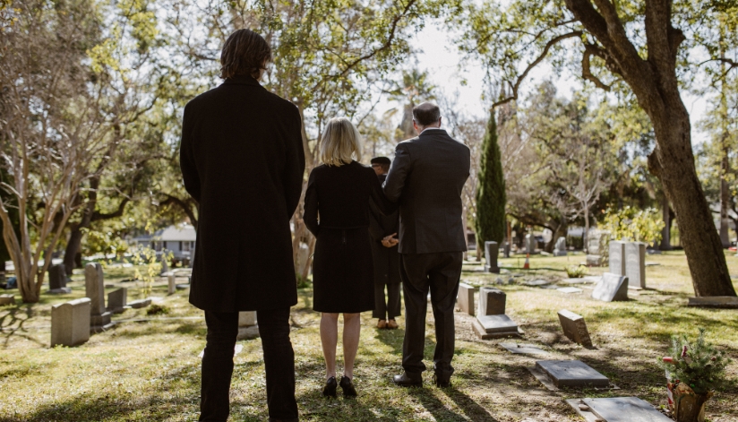 A grieving family at the graveyard for a funeral for a loved one in a wrongful death situation.