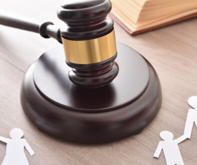 Paper cutouts of a family with a judge''s gavel in the middle.