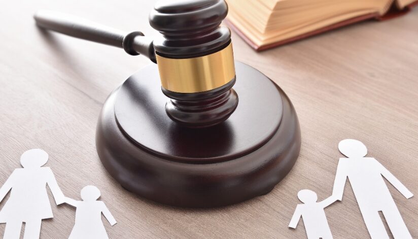 Paper cutouts of a family with a judge''s gavel in the middle.